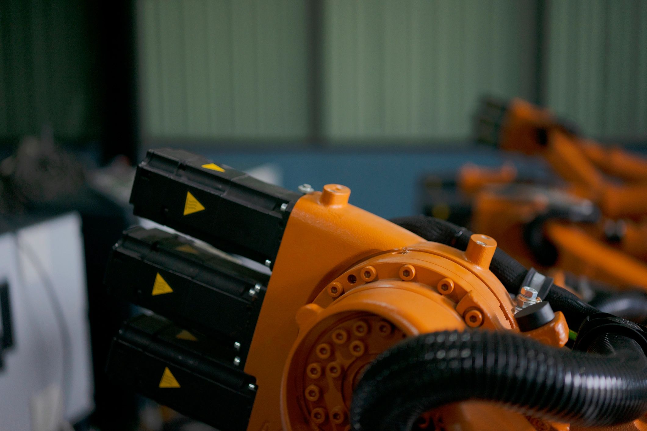 Engineer working near robotic arm equipment in a factory